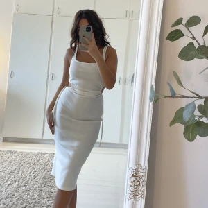 Vit Klänning  - Vit medellång klänning från chiquelle med slits. Vit och helt oanvänd. Midjan kan du justera själv och ger dig en fin form✨