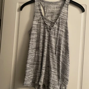 Linne från hollister - Fint linne från hollister som är knappt använd. Är som nyskick. Har en grå vit färg. 