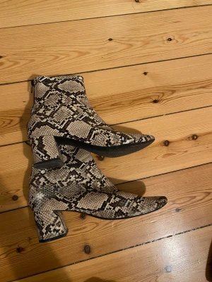 Boots i ormskinnsmönstrad strl 36 - Ormskinnsmönstrat läder från Mango. Storlek 36z. Säljes pga flytt. 