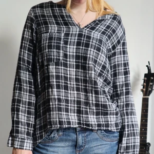 Flanellskjorta svart & vit rutig - Flanellskjorta svart och vit randig. Utan knappar men två fickor över bysten. Perfekt skick! Säljer då jag ej använder längre ☑️