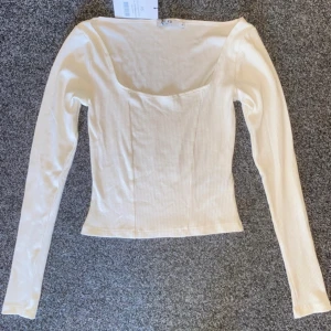 Vit långärmad T-shirt  - Vit långärmad T-shirt. Aldrig använd, prislapp kvar.