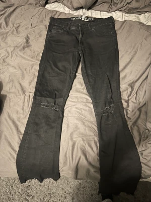 Jeans HM - Jeans med hål på knäna och fransar vid foten 