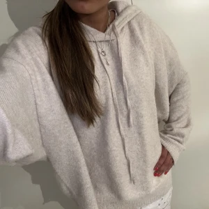 Stickad hoodie - Säljer denna jätte fina stickade hoodie i jätte skönt material i en beige vit färg den är väldigt använd! Nopprig!