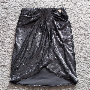 Kjol med paljetter  - Kort kjol med svarta paljetter. Storlek S. Oanvänd. Märke Chiara Forthi.   Betalning sker via swish och köparen står för frakten. 
