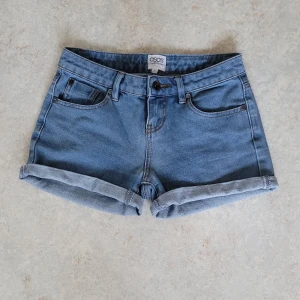 Jeansshorts - Fina jeansshorts i storlek 34 från Asos. Har dragkedja och knapp i fram, även fickor både bak o fram. Säljer p.g.a. att de är lite för tighta i midjan för mig. 