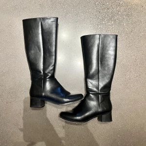 Svarta stövlar - Fina svarta stövlar perfekta till höst/vinter! Stl 39 (passar mig som varierar mlln 39/40) finns lite repor på utsidan och på klacken, annars bra skick:) Endast använda ett fåtal gånger.