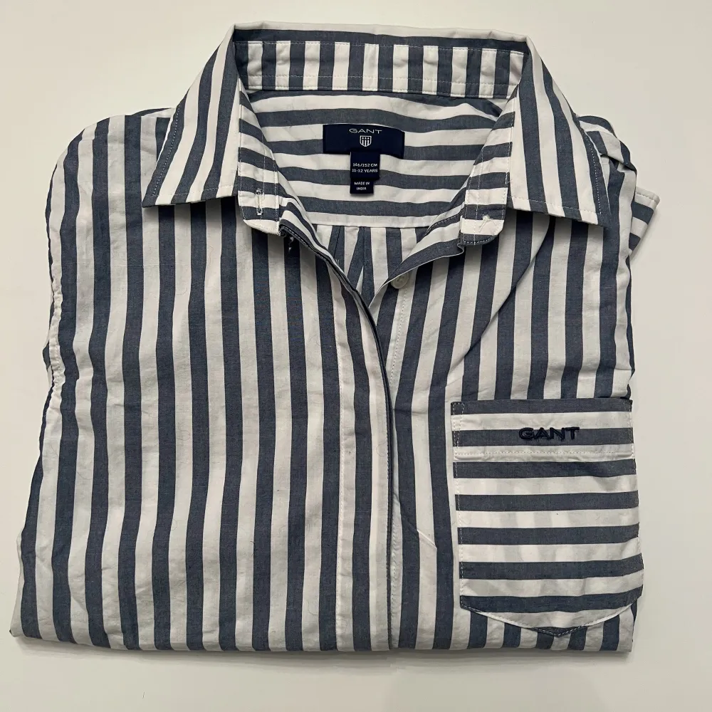 Snygg skjorta använd fåtal gånger och utan några defekter, därav i nyskick. Storleken är 146/152 eller XXS så perfekt om du vill att den ska sitta lite tajtare.  Nypris runt 1000❤️. Skjortor.
