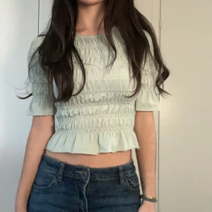Fin krinklad topp - Jag säljer nu denna fina gröna topp då den inte längre kommer till användning💞Tröjan är väldigt bra skick, den är i storlek xxs men är väldigt stretchiga och passar även xs/s. Köparen står för frakt💗skriv om ni har någon fråga💕💕