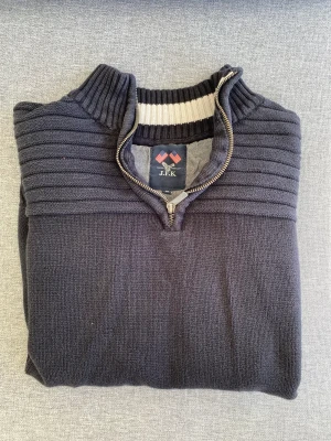 Half zip, J.F.K - Säljer min J.F.K half zip marin blå. Den är 100% bomull och är i utmärkt skick. Den är i storlek M men skulle säga att den är en aning mindre.