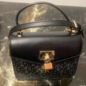 Säljer min underbara DKNY väska  - Säljer min DKNY väska eftersom jag har ingen användning av den längre! Köpet för ett 1300kr säljer från 670kr. Använd och det syns lite men inte så synligt om man inte läger märke till de. Vid fler funderingar eller bilder är det bara att höra av sig💕
