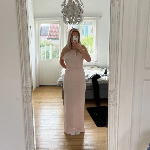 Balklänning - Rosa långklänning/balklänning med spets och slits baktill från Nelly. Aldrig använd  Passar XS-S / 34-36