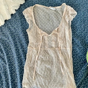 Ljusrosa/beige spetstopp - Supersöt vintage spetstopp i ljusbeige/rosa! Kan knytas en rosett framtill💞 storlek S men passar xs och eventuellt M