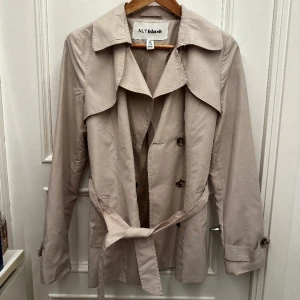 Trenchcoat  - Tunn beige trenchcoat från NLY Blush. Storlek 36. Fint skick förutom liten fläck på höger sida(se första bild).