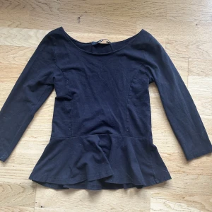 Blå tröja med trekvartslånga armar. - Svart trekvarts arm tröja! Volanger längst ner. 