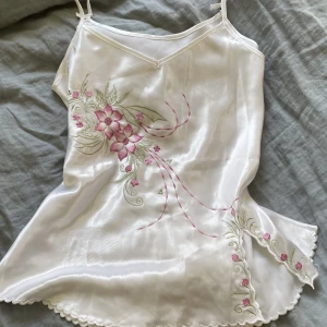 Vitt linne  - Gulligt linne med broderier av blommor har ett märke på vänster sida som man knappt ser. Linnet är knutet i banden (se sista bilden). Säljer då den är för liten för mig!