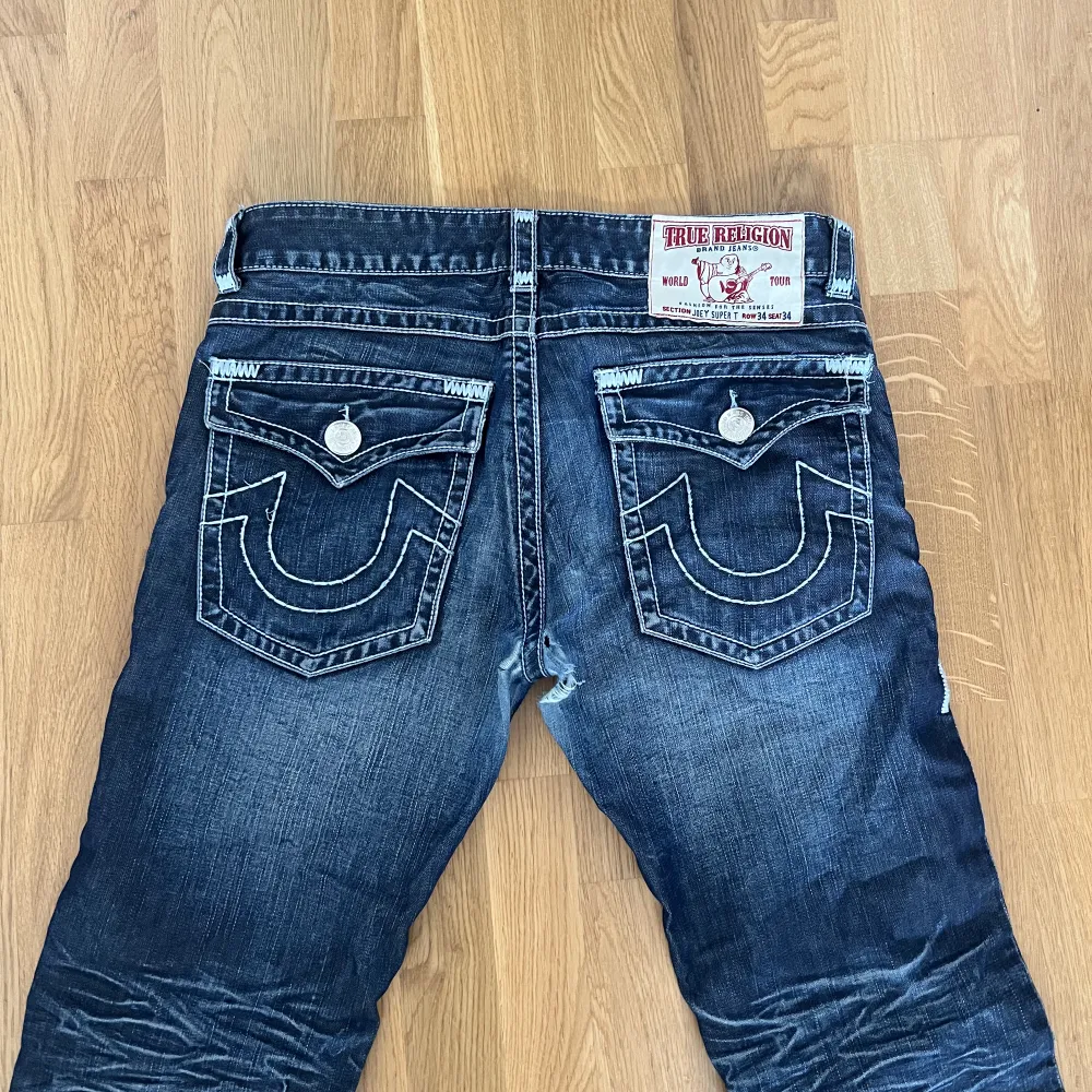 super snygga true religion jeans, Bra skick förutom ett ”hål” (se bild 2 för skada) inget som syns vid använding. Strl 34x34 men passar mig som är 32 i längd, kan vara något slitet nertill. Regular fit !! Sänkt pris från 400. Jeans & Byxor.