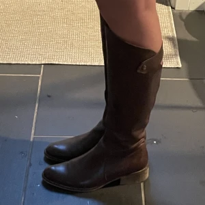 Bruna stövlar - Bruna stövlar med låg klack. Hål på baksidan längst upp på skon som man ser på andra bilden. Använda men fina! Skriv privat för fler bilder😊