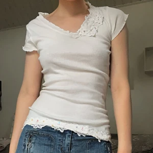 Vit topp - Supersöt vit ribbad topp med små blommor som detaljer, storlek M men passar på mig som brukar ha XS-S. Perfekt nu till sommaren😍