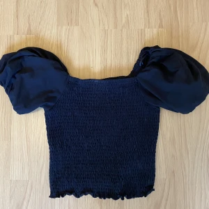Topp från ginatricot - Svart topp med puffiga ärmar från Ginatricot, andvänd 1 gång, storlek M!