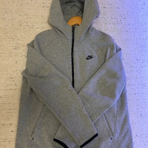 Nike tech kofta - En gråa och sällsynt nike tech kofta som fortfarande är i väldigt bra skick, använd 3-4 gånger passar perfekt nu till vintertiderna