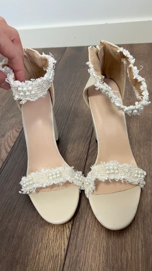 Klackar med pärldetaljer - Klackar med pärldetaljer. Aldrig använda. Strl 38 men lite stora i storleken.