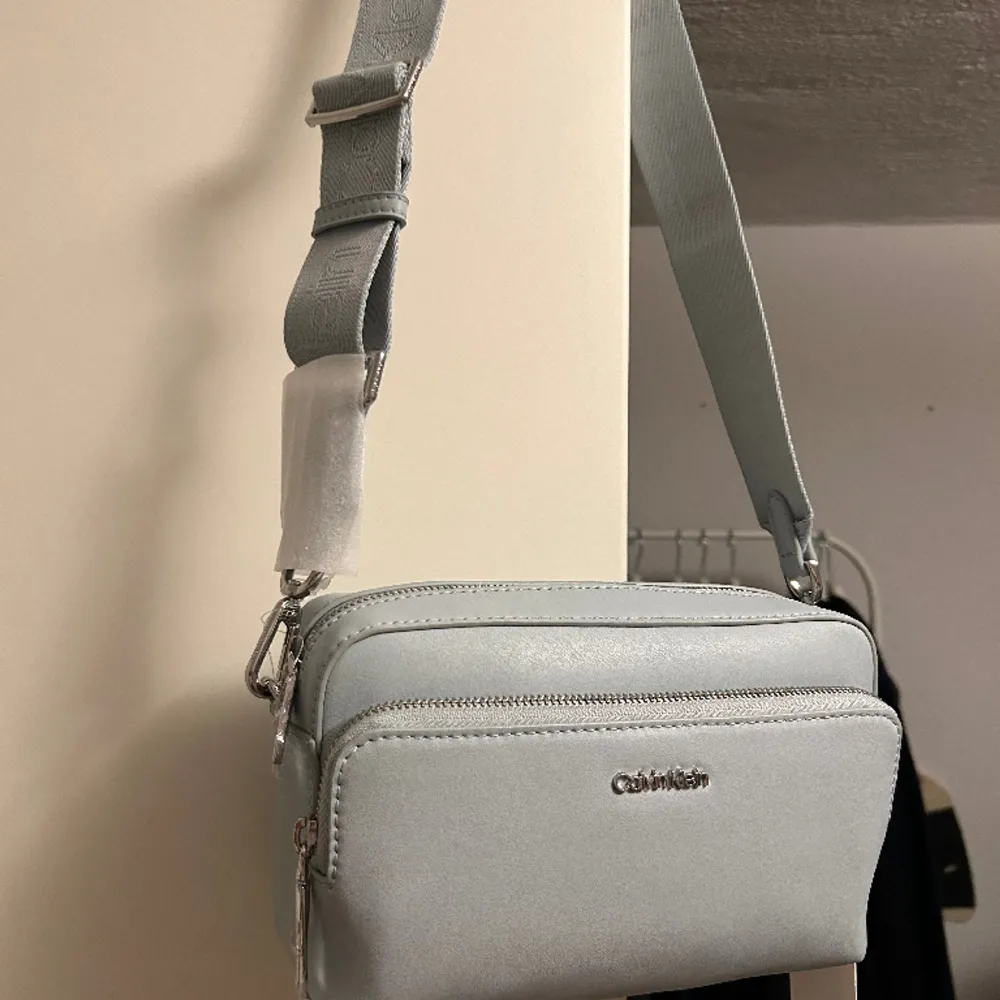 Helt Ny: Calvin Klein Must Camera Bag Unisex - Axelremsväska, Helt slutsåld online . Väskor.