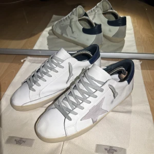 Golden goose skor - Säljer mina Golden goose superstar i skick 8.5/10. Liten skada på insidan av högerskon som knappt synns när skorna är på men man ser den om man kollar. Tillkommer: endast skorna. Hör gärna av dig med funderingar eller om du vill ha fler bilder🤝