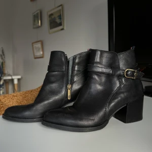 Tommy Hilfiger stövletter  - Strl: 38 (true to size)  Märke: Tommy Hilfiger Modell:  Sardinia 2A FW56821606 (nypris ca 2200kr  Material: äkta läder  Skick: Välanvända, finns synliga slitningar på tex baksida klack (se bild 3) + vanliga slitagetecken vid användning. 