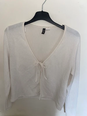 Vit blus - Detta är en vit blus som har blivit Andvänd 1-2 gånger, snöret där framme går att knyta up, det är en l men skulle tro att den passar mindre och större storlekar😊priset kan diskuteras  