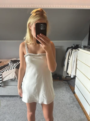 Vit satinklänning Zara - Säljer denna super fina vita satin klänning med glittriga detaljer från Zara som inte säljs längre! Klänningen är i så gott som nyskick i storlek M. Säljer då den inte längre kommer till användning. (Köparen står för frakt) 🥰