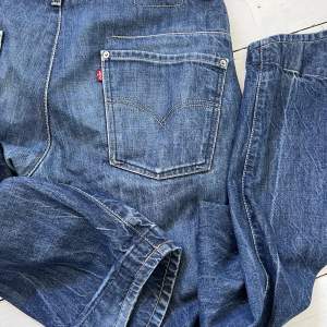 Legendariska Twisted jeans från Levi’s. Superfin mörkblå tvätt som fått en fin slitning. Byxorna är helt intakta och är inte på väg att spricka någonstans trots fin slitning