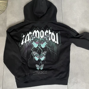 Svart Hoodie med tryck - Älskar denna tröjan men använder inte då jag köpt nytt. Inköpspris var runt 350kr och jag säljer den för 70kr+ frakt