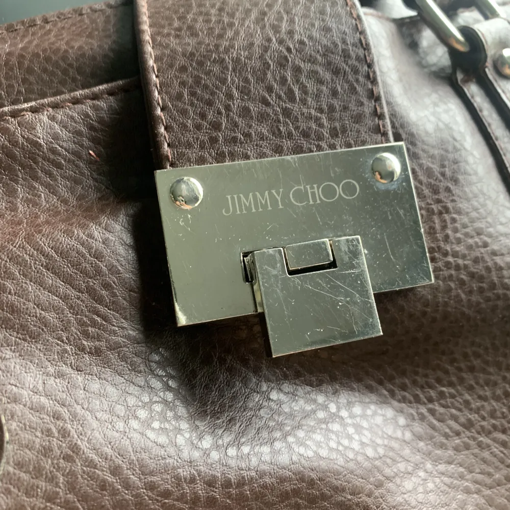 Köpt Jimmy choo väska på human för 370kr så inte äkta. Har använts två gånger av mig men har ändå lite repor på metallen samt lite ömtåliga tyg i väskan men många bra fack och snygg brun färg . Väskor.