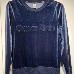 Långärmad blå tröja från Calvin Klein sleepwear. Skön och snygg sovtröja i mycket bra skick! Materialet är crushed velour!