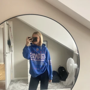 Hoodie - En blå hoodie med olika tryck på sig, från pull and bear 