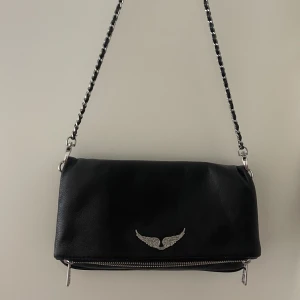 zadig väska - Säljer min zadig rock clutch då den inte kommer till användning längre. Skicket är precis som när jag köpte den, längre kedja följer även med. (kvittot är sparat) 💛🩷❤️‍🔥 Nypris 3500 (frakt ingår)