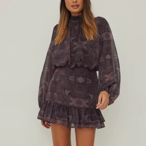 Klänning - En såååå fin lila mönstrad klänning från NA-KD i den perfekta passformen⭐️😭 Strl 38 med dragkedja och knap baktill🤩 !finns en liten slitning vid sömen över rumpan men inget som skadar eller syns på klänningen! (Frakt tillkommer!)🥰