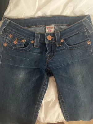 True Religion Jeans - Ett par äkta true religion jeans i storlek 25. De har en liten blekning som inte syns vid användning som man ser på bild 2 och byxorna är igensydda längst ner och därav de billiga priset. #truereligionjeans #true religion 