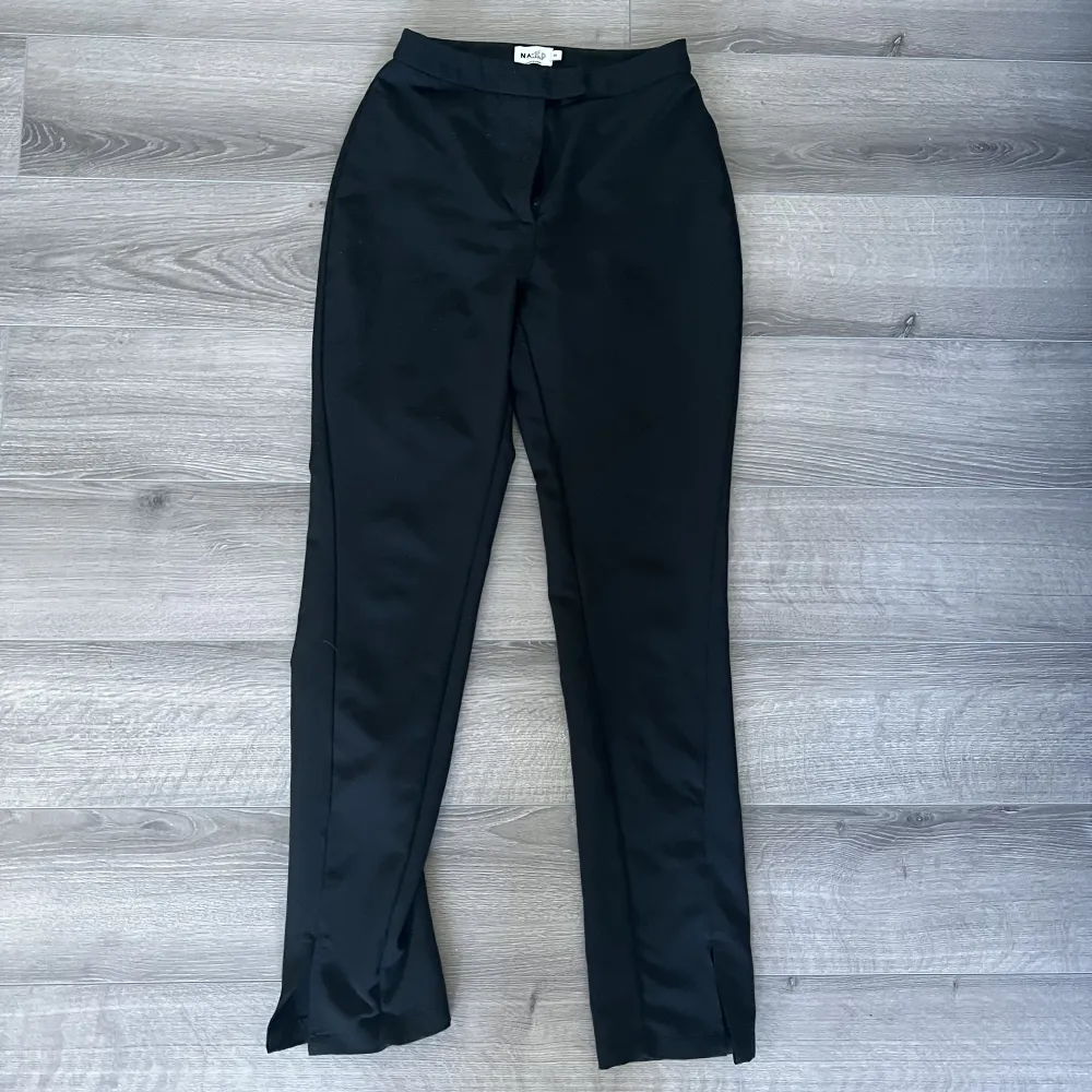 Svarta kostymbyxor från NAKD. Med en slit nere vid benet. Storlek 34. Väldigt stretchiga och bekväma. . Jeans & Byxor.