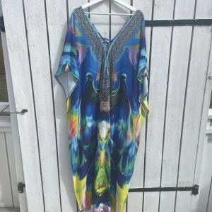 Vackert strandplagg eller klänning. - Lång klänning med fina detaljer. Inköpt i Dubai. Fjärils armar. Lättare resår i midjan.