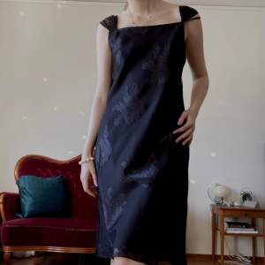 En svart slip dress med rosmönster, snörning på baksidan och ett mesh lager. Köpt second hand men jag har aldrig använt.  Står ingen storlek eller märke men jag skulle säga S-M