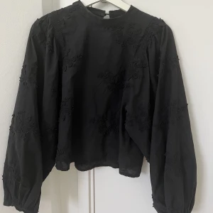 Svart blus - En perfekt svart blus med volang ärmar! Passar perfekt till allt. Blusen har små broderade blommor på 💕💕