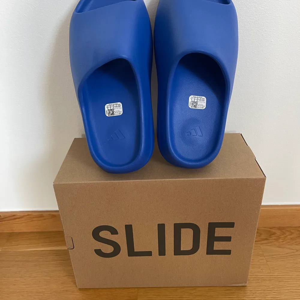 Helt nya Yeezy Slide Azure i storlek 43 (passar 41/42) säljes. Inköpta via Adidas CONFIRMED och digitalt kvitto finns.  Hämtas i Örnsköldsvik eller skickas på köparens bekostnad.. Skor.