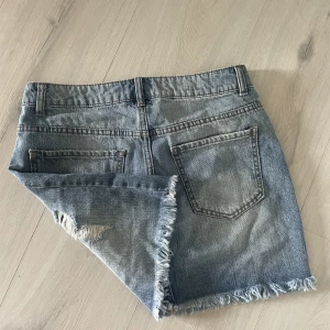 Jeanskjol - Kort mörkblå jeanskjol. Står ingen storlek men skulle säga XS/S. Ganska tajt runt midjan. 