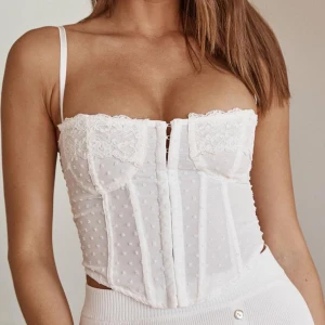 Korsett topp - Korsett topp från Chiquelle i färgen vit. Den är i storlek 36 men upplever den mer som en 34. Kuporna är också små. Aldrig använd. 