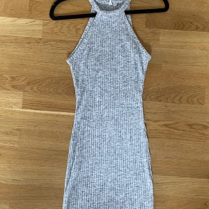 Figurnära kort ribbad klänning  - Olika toner av grå storlek XS  Stretchig tyg Från Nelly  Använd fåtal gånger Fint skick och inga defekter 