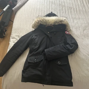 Canada Goose jacka - Säljer min Canada Goose nu, den var kemtvättad förra året💕Den är fint behållen, men den enda defekten på jackan är små hål längst ner vid armarna. (Kan gärna skicka bild). Färger har inte tvättat bort sig och pälsen är äkta så klart💕