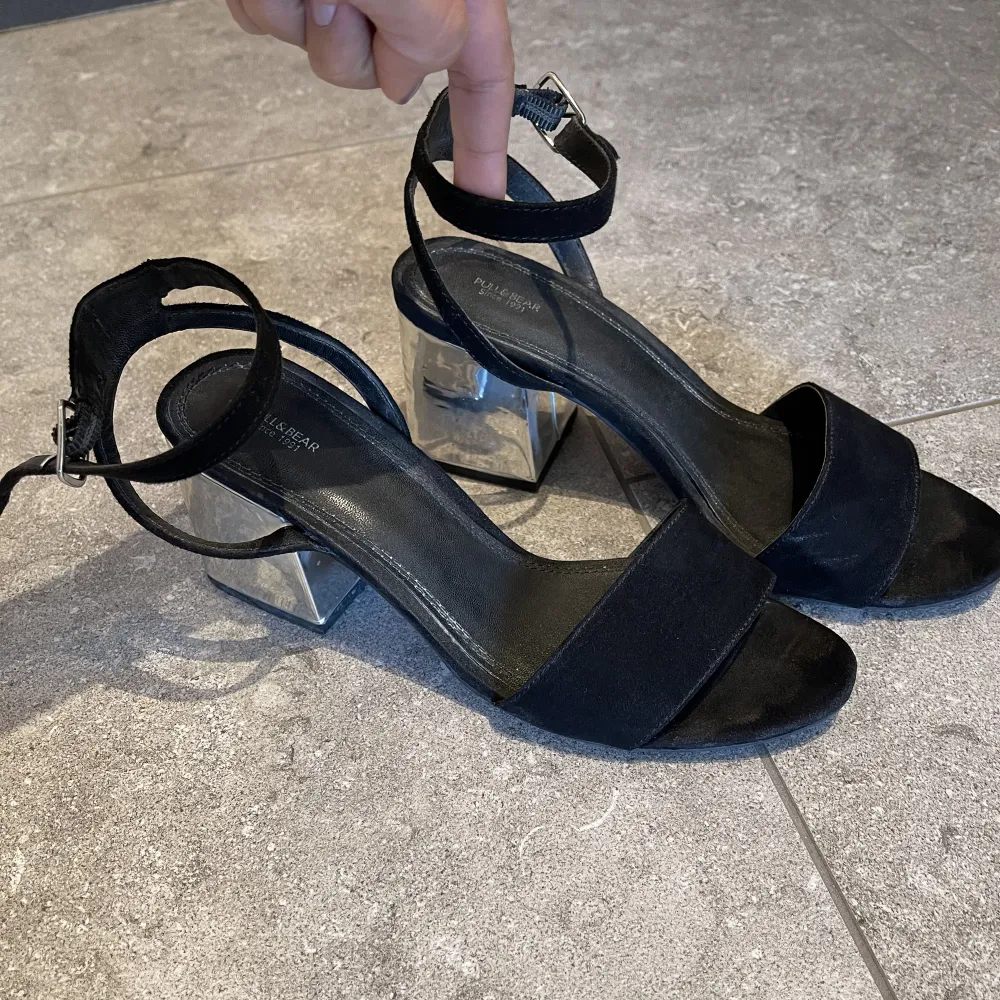 Sandals with 7 cm heel. The fabric is black velvet and the heel is silver, giving it a touch of shine, they tie at the ankle and are very comfortable. They are clean with no defects. Skor.