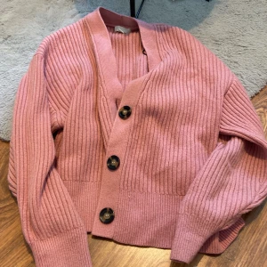Stickad kofta - Rosa stickad kofta med knappar, använd ett fåtal gånger. Varm och skön inför hösten