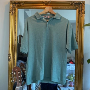 Fila Mintgrön Piké tröja - En typ mintgrön fila pike i storlek Large. Säljes då den sällan används och jag har fått så liten garderob, men den är i mycket fint skick!